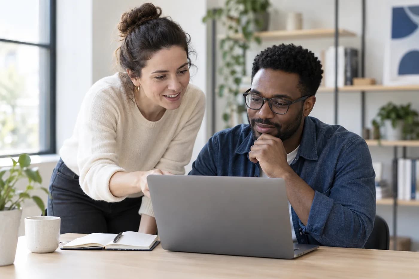 An educator guiding an adult learner through an exercise on a laptop.